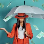 woman holding an umbrella being showered by cash