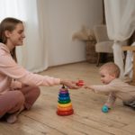 smiling woman playing with a small child