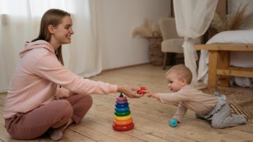 smiling woman playing with a small child