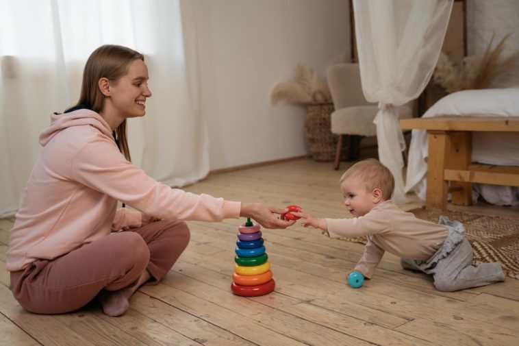 smiling woman playing with a small child