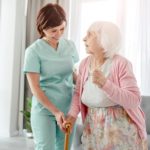 nurse helping an elderly woman walk