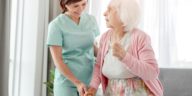 nurse helping an elderly woman walk