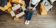 woman with a laptop in her lap surrounded by boxes