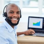 sales representative wearing a headset working on a laptop