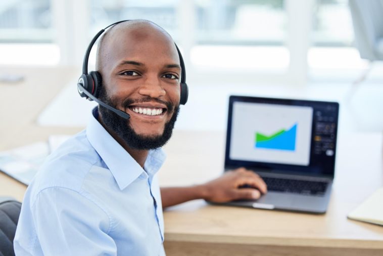 sales representative wearing a headset working on a laptop