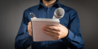 journalist holding microphone notepad and pen