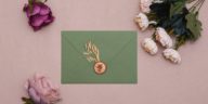 green envelope with gold stamp and flowers around it