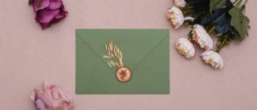green envelope with gold stamp and flowers around it