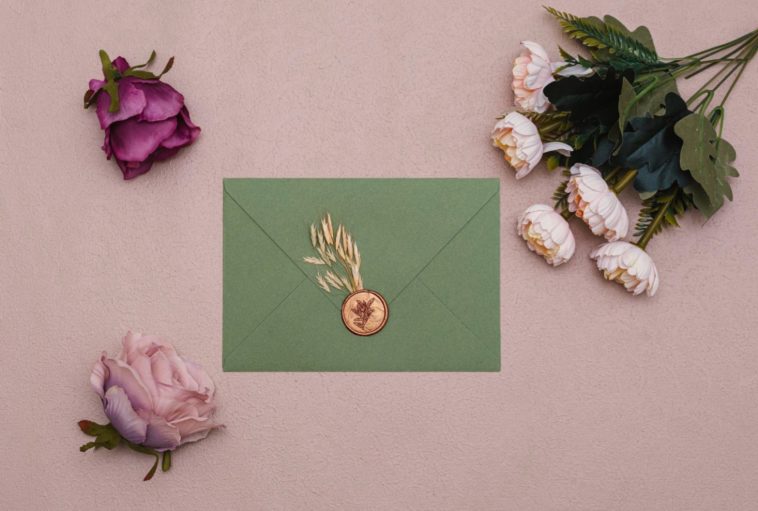 green envelope with gold stamp and flowers around it