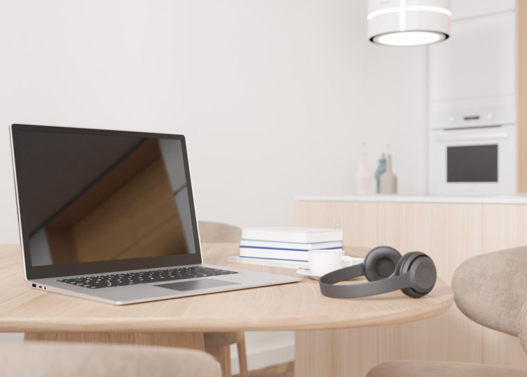 a laptop, headphones and books on a table in someone's home