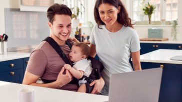 family with baby looking at a laptop screen