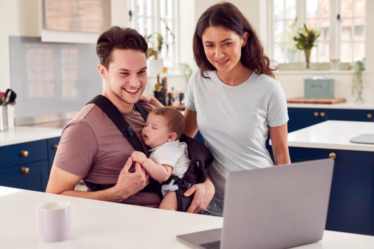 family with baby looking at a laptop screen
