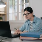 woman sitting at a desk working on a laptop