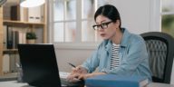 woman sitting at a desk working on a laptop