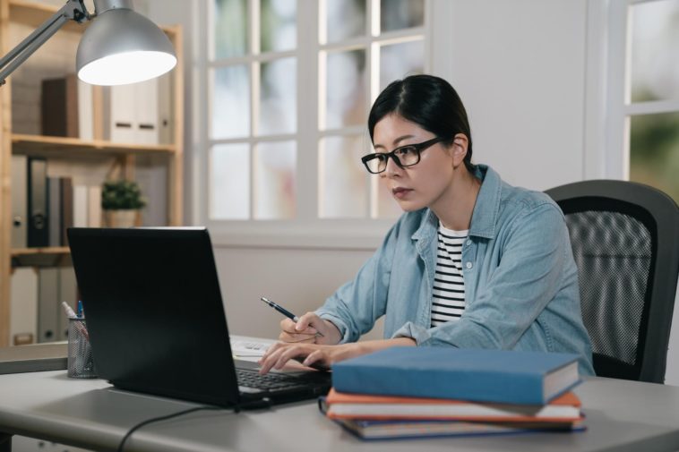 woman sitting at a desk working on a laptop