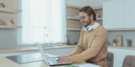 man with headphones working from home using a laptop