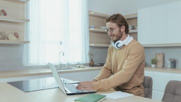 man with headphones working from home using a laptop