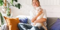 woman sitting on a couch holding a cat