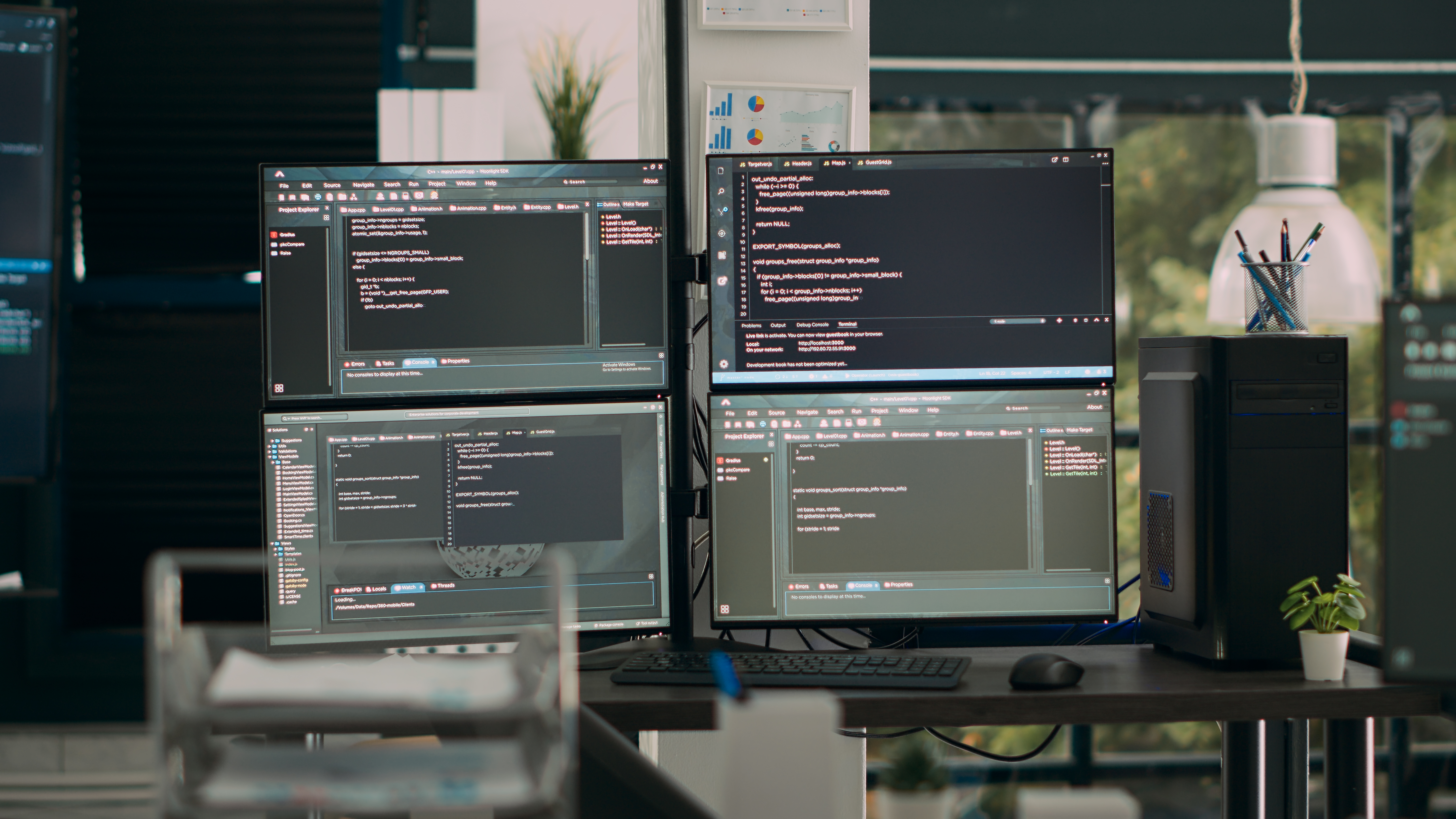 office desk with multiple screens running software developing scripts