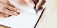 female hands writing with pen in a notebook