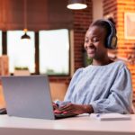 woman working at a laptop with headphones on