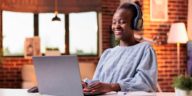 woman working at a laptop with headphones on