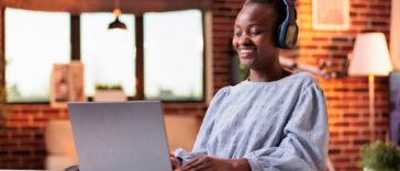 woman working at a laptop with headphones on