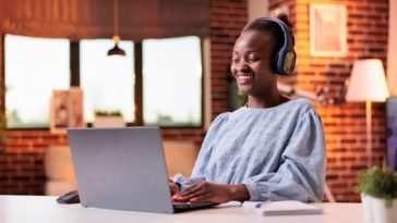 woman working at a laptop with headphones on