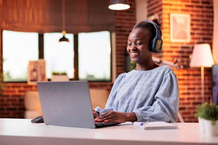 woman working at a laptop with headphones on