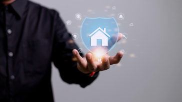 man holding a 3d icon of a house inside of a shield