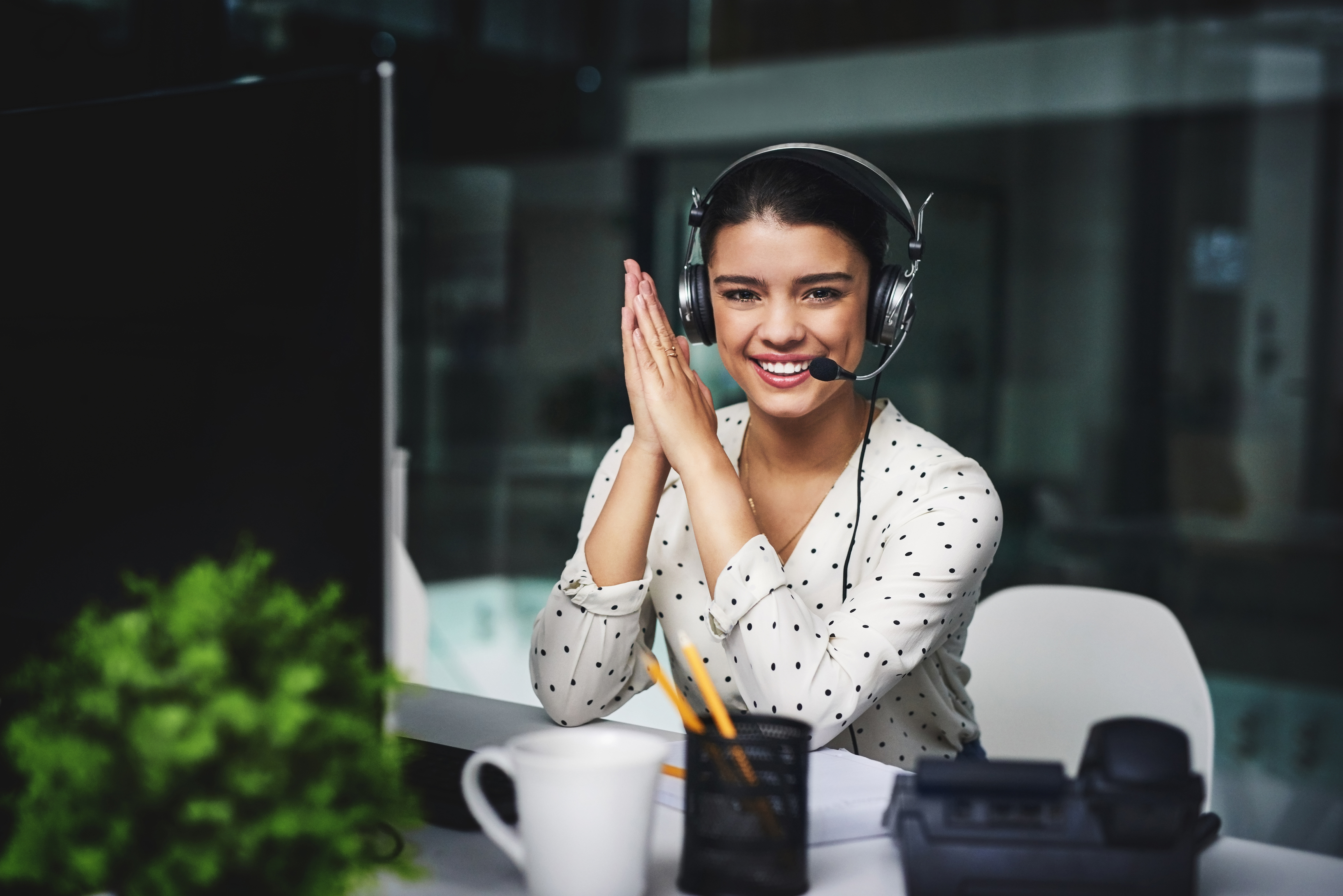 smiling woman with a headset working in an office