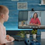 little girl on a video call with a teacher