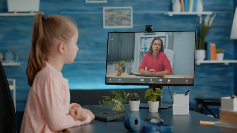 little girl on a video call with a teacher