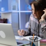 woman sitting at a desk wearing headphones