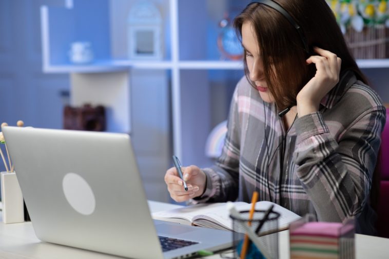 woman sitting at a desk wearing headphones