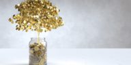 tree made of gold coins growing out of a jar of coins
