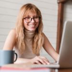 woman working on a laptop and smiling