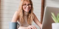 woman working on a laptop and smiling