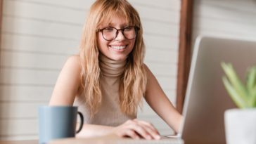 woman working on a laptop and smiling