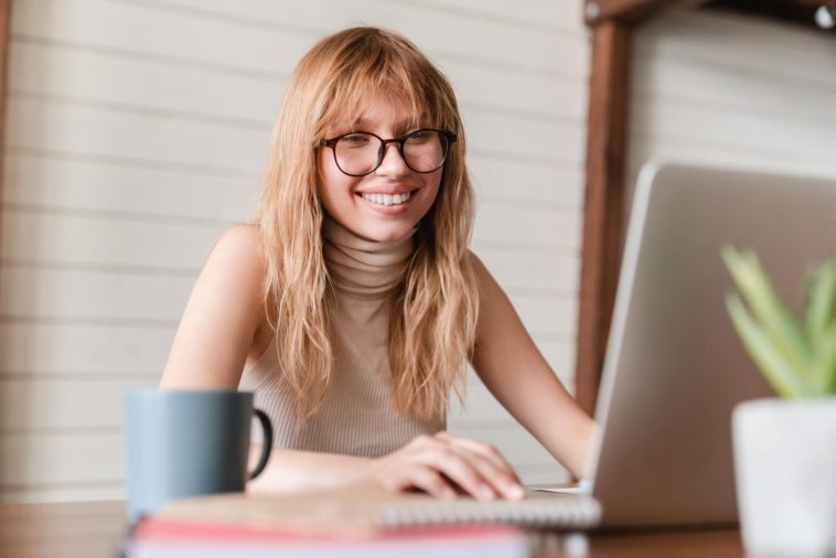 woman working on a laptop and smiling