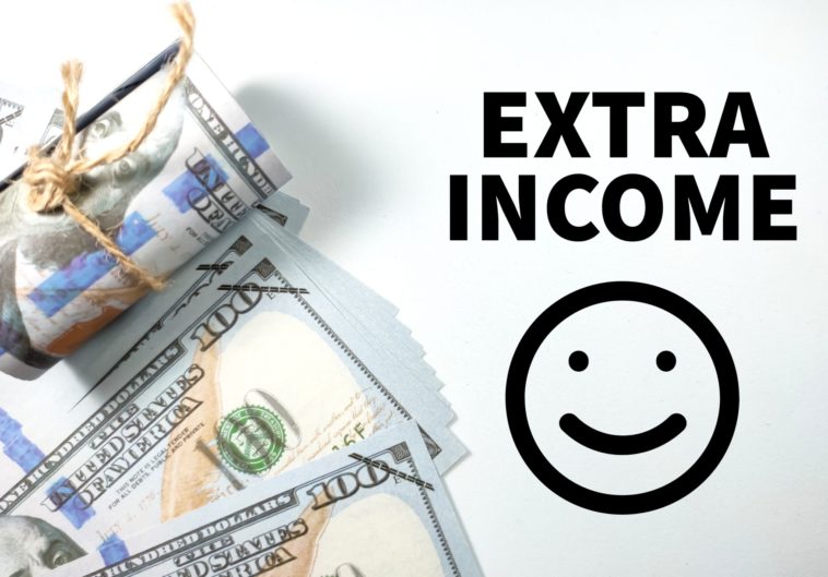 dollar bills next to an extra income and smiley face drawing in black