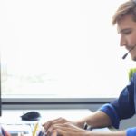 man with headset working on a computer