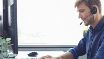 man with headset working on a computer