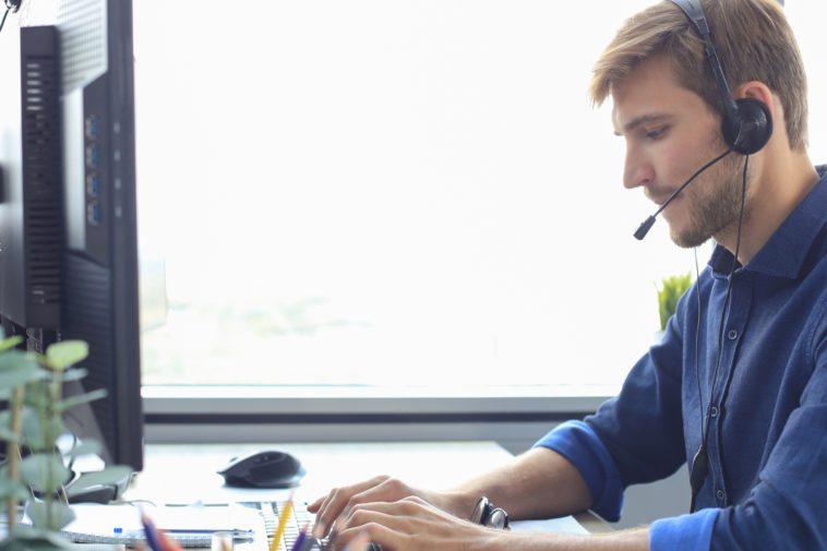 man with headset working on a computer