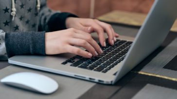 woman hands typing on a laptop