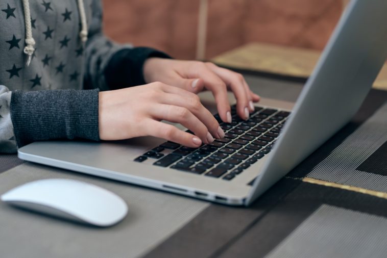 woman hands typing on a laptop