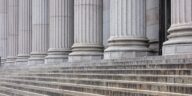 row of white stone pillars and classical stairs