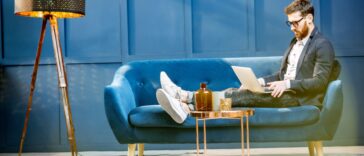 man sitting on a couch and working on a laptop