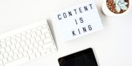 content is king sign next to a computer keyboard