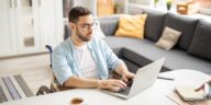 man in a wheelchair working on a laptop from home